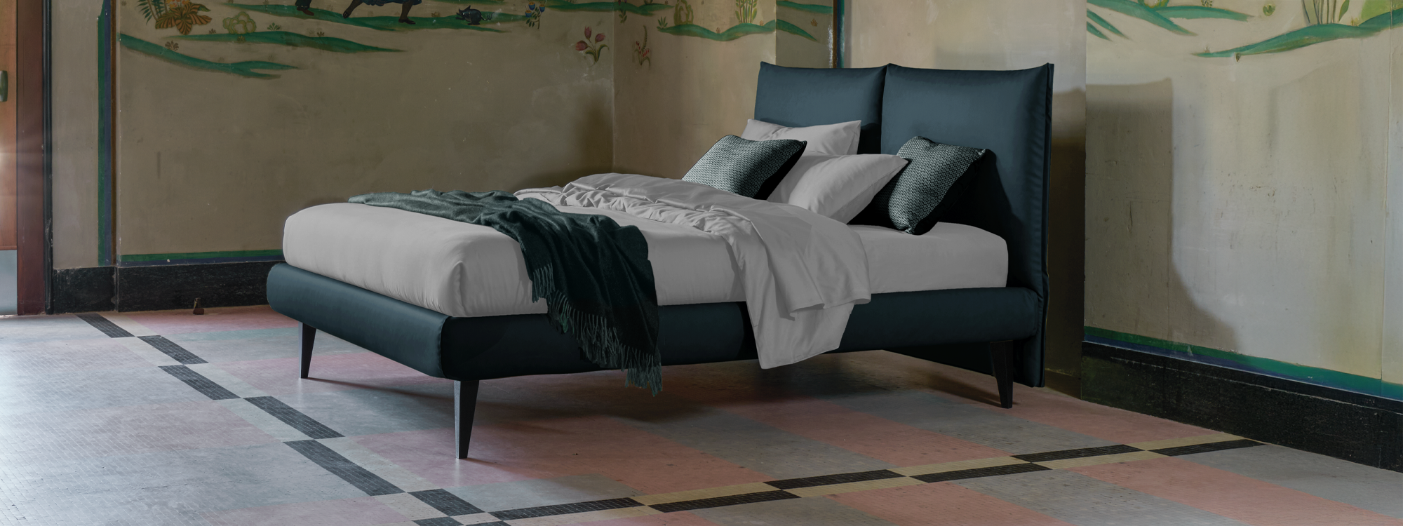 letto compatto facile da pulire con due grandi cusciature. letto blu con lenzuola grigio