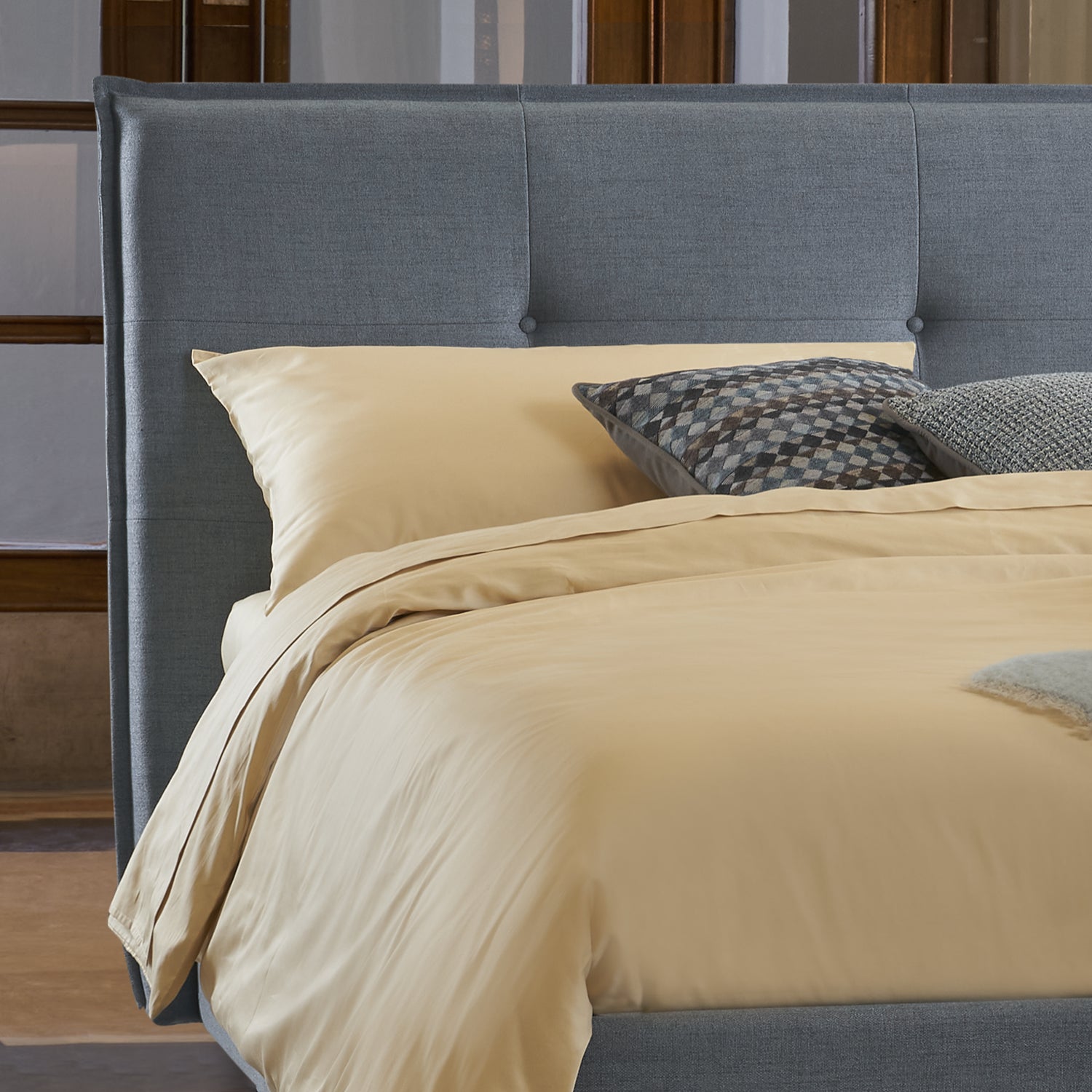 dettaglio letto victor, con trapuntatura leggera, letto compatto per spazi piccoli di colore ceruleo con lenzuola crema e cuscini decorativi