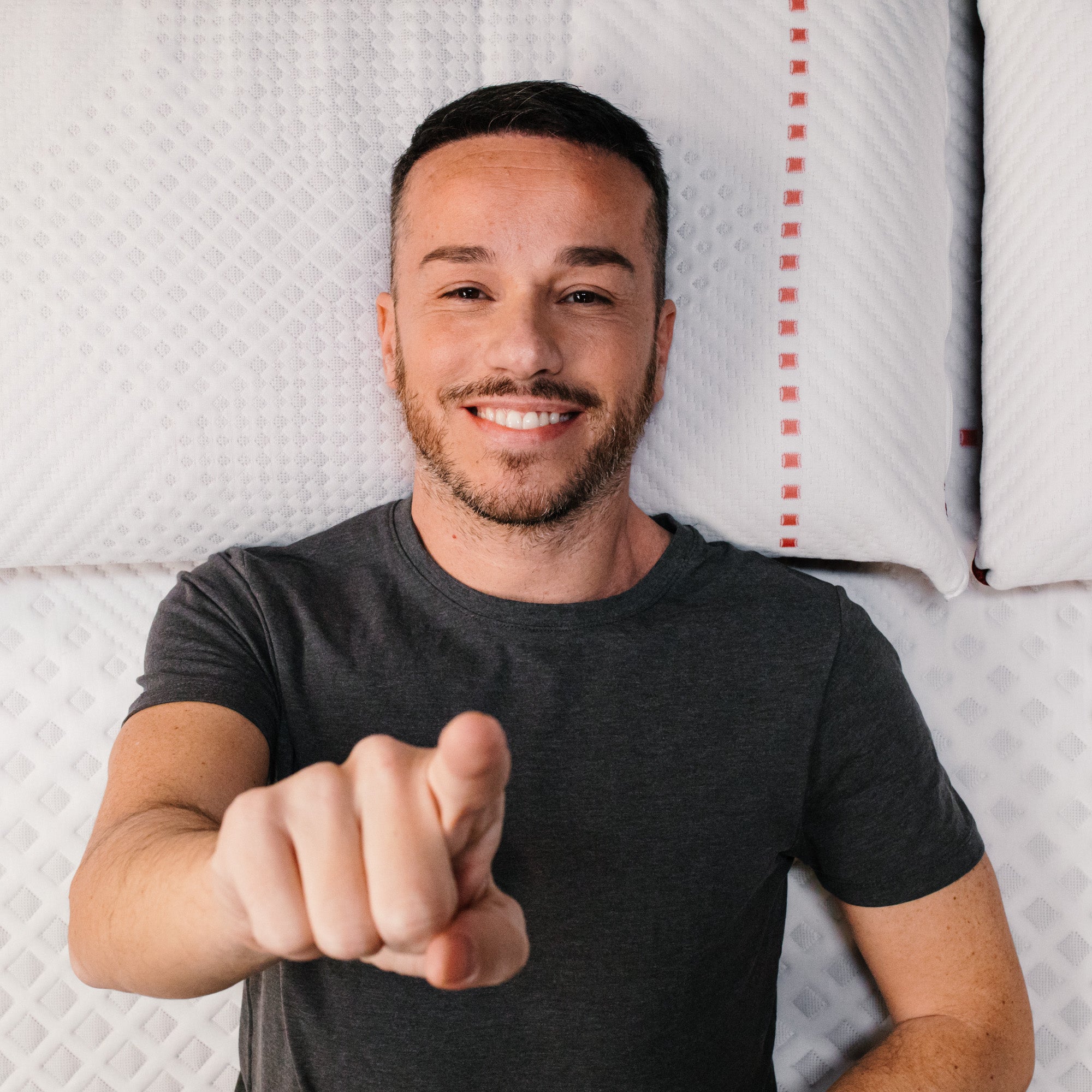 ragazzo steso su un materasso ti indica invitandoti a iscriverti alla newsletter