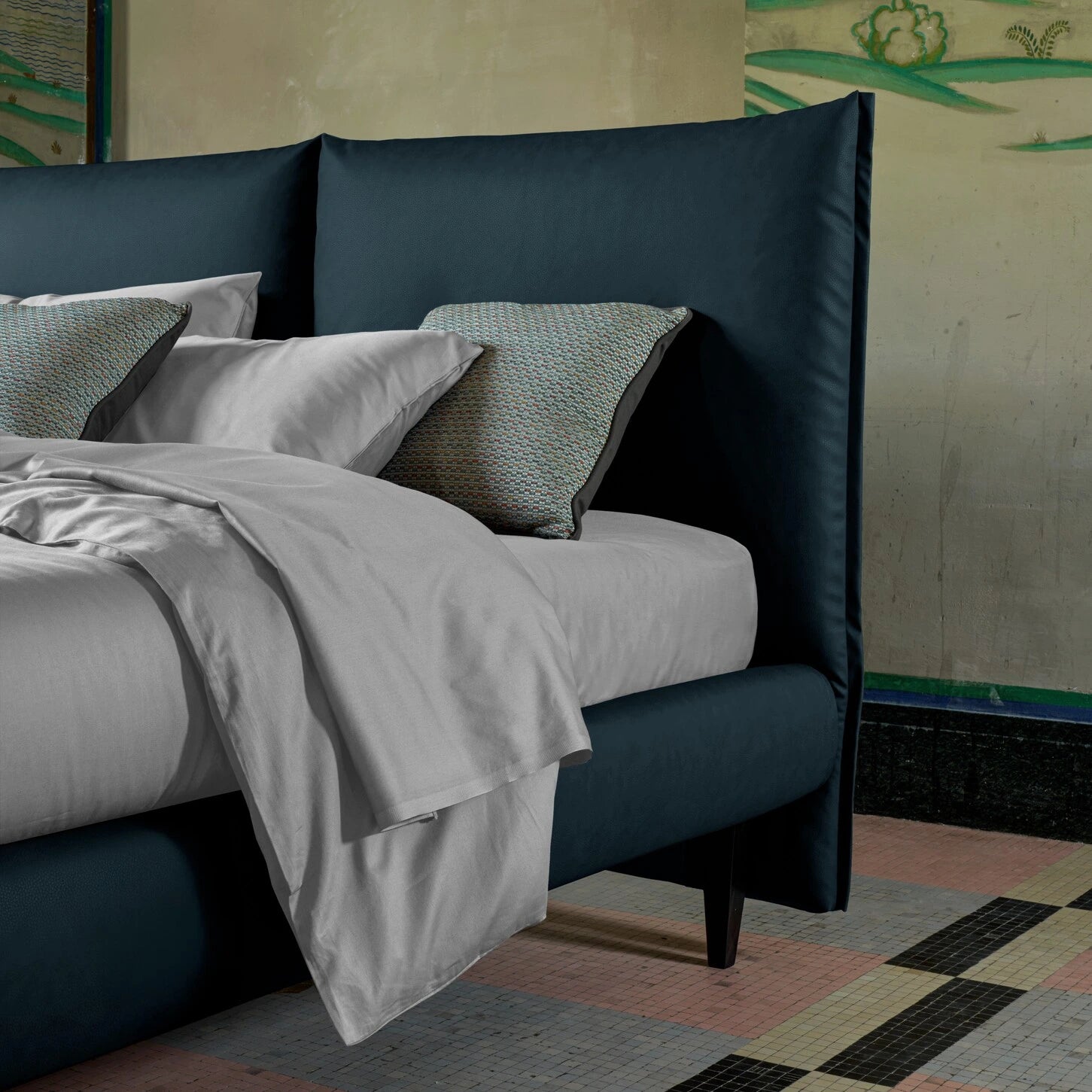 letto frank blu con lenzuola chiare. letto compatto con testiera piccola in contesto architettonico elegante