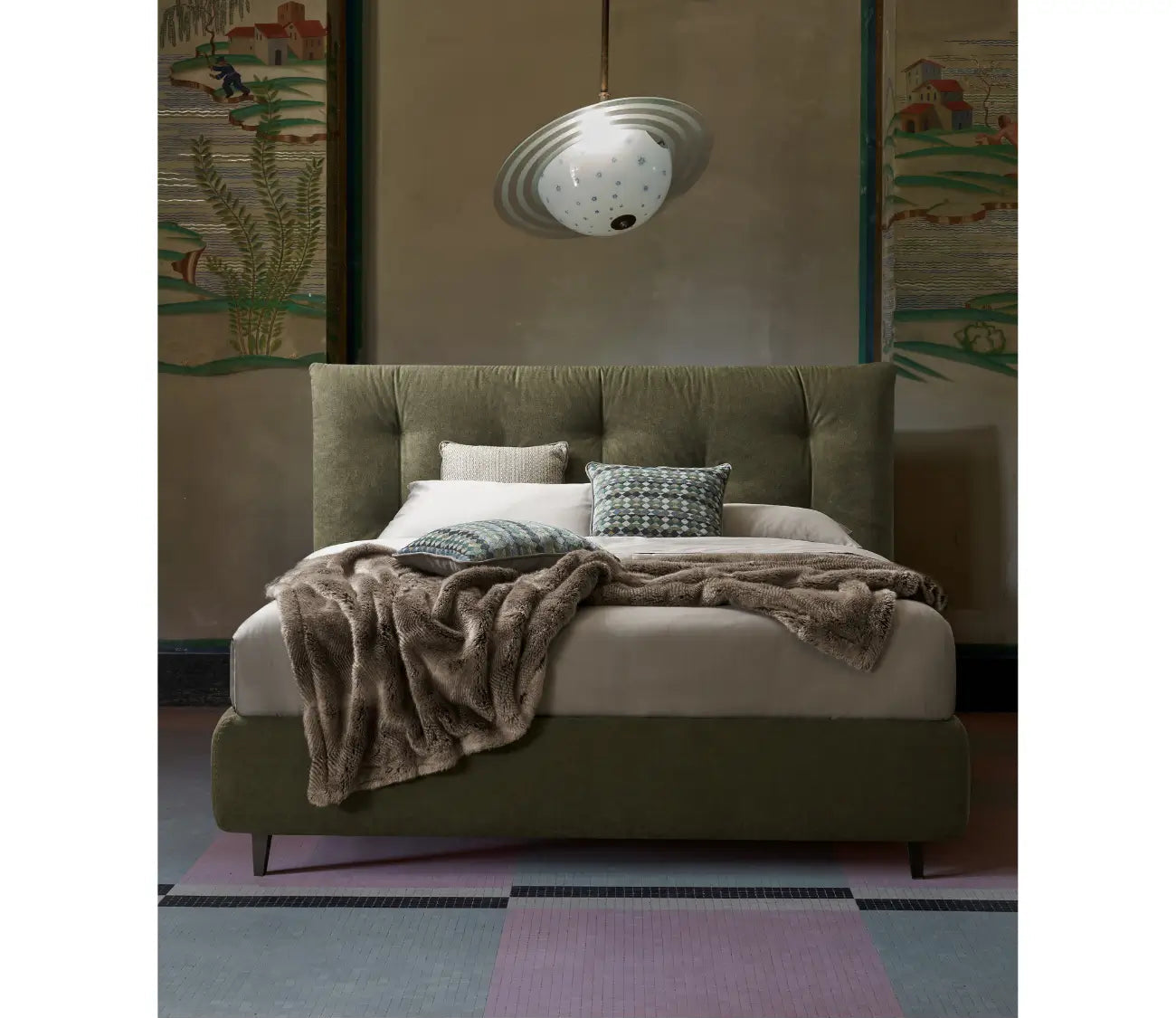 Letto imbottito verde oliva con testiera trapuntata, lenzuola grigie e cuscini decorativi in una camera elegante e moderna