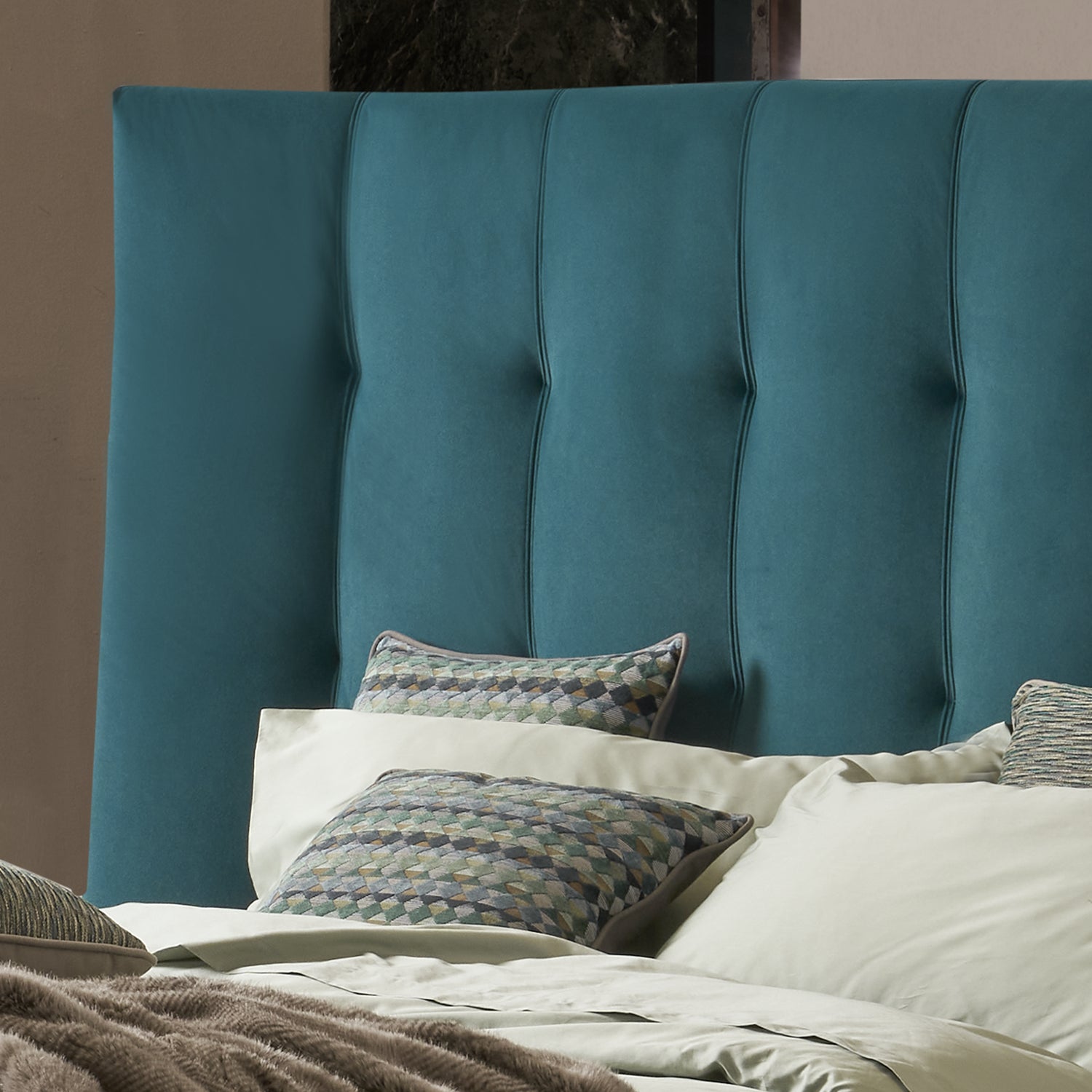 dettaglio testiera trapuntata letto elegante con testiera grande color ottanio e cusicni decorativi