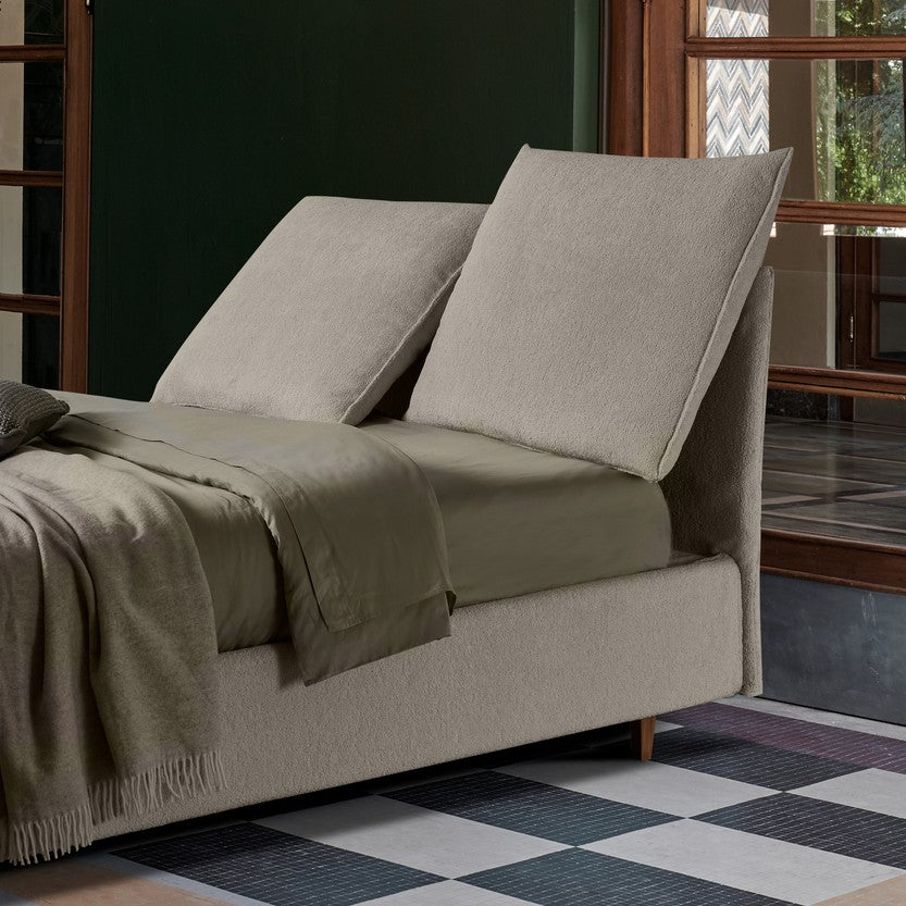 letto color beige con testiera relcinabile e regolabile, con lenzuola color pistacchio