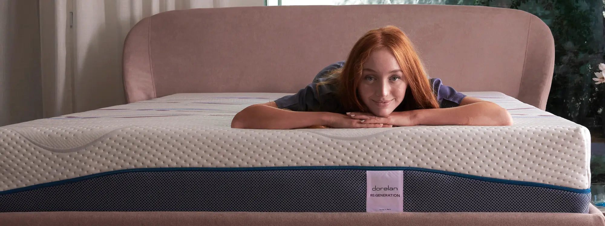 Camera luminosa: donna appoggiata al materasso Dorelan Re:Generation con testiera ros