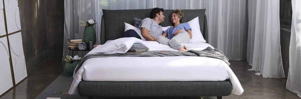 coppia stesa nel nuovo materasso matrimoniale dorela in camera moderna
