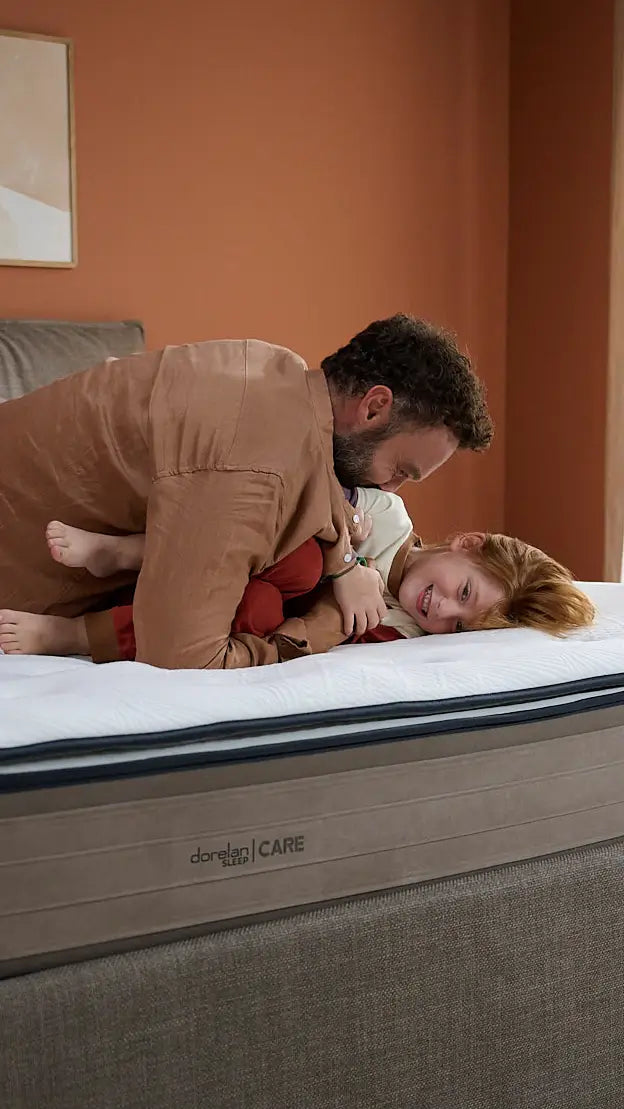 padre e figlia giocano assieme sul letto. è fondamentale avere le energie per giocare con i propri figli