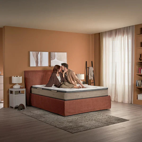 Coppia distesa sul materasso Allura Dorelan della collezione Sleep CARE, materasso a molle indipendenti pensato per offrire comfort avvolgente, benessere e sostegno ergonomico durante il riposo.
