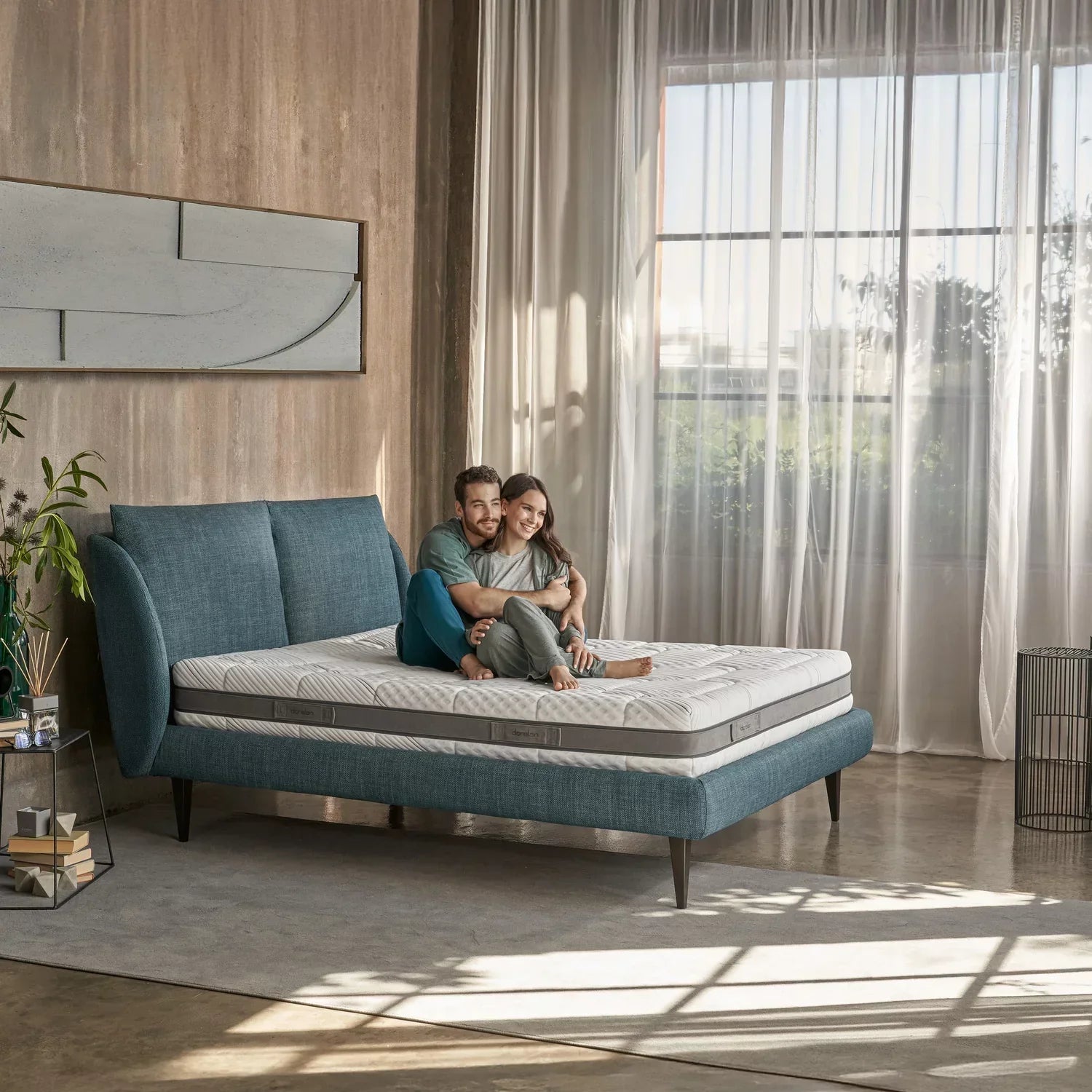 Coppia seduta sul materasso Myform Nube Dorelan, in una camera moderna e luminosa, esempio di materasso in Myform memory.