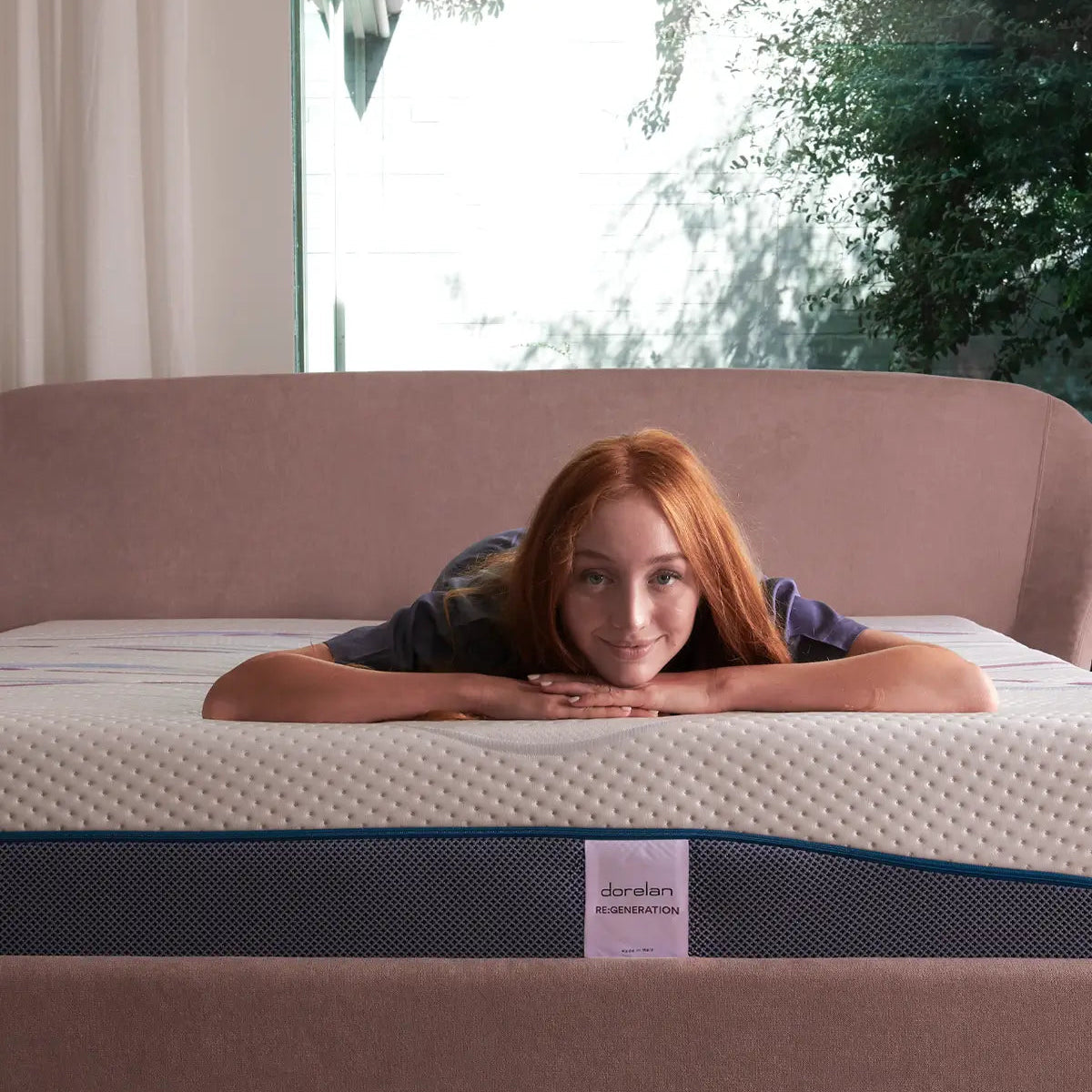 Camera luminosa: donna appoggiata al materasso Dorelan Re:Generation con testiera ros
