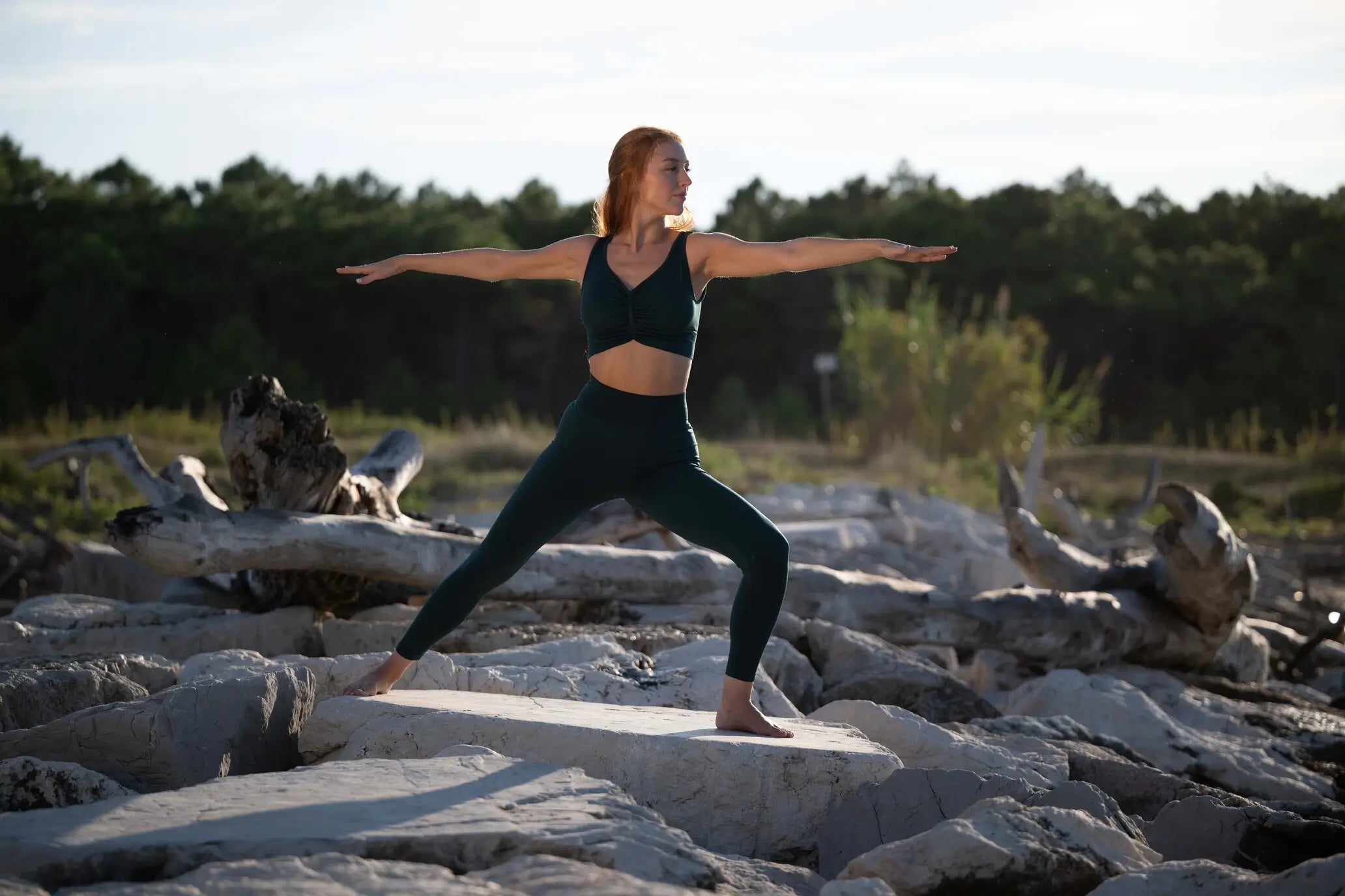 ragazza si sta rigenerando: pratica yoga sugli scogli del mare l tramonto