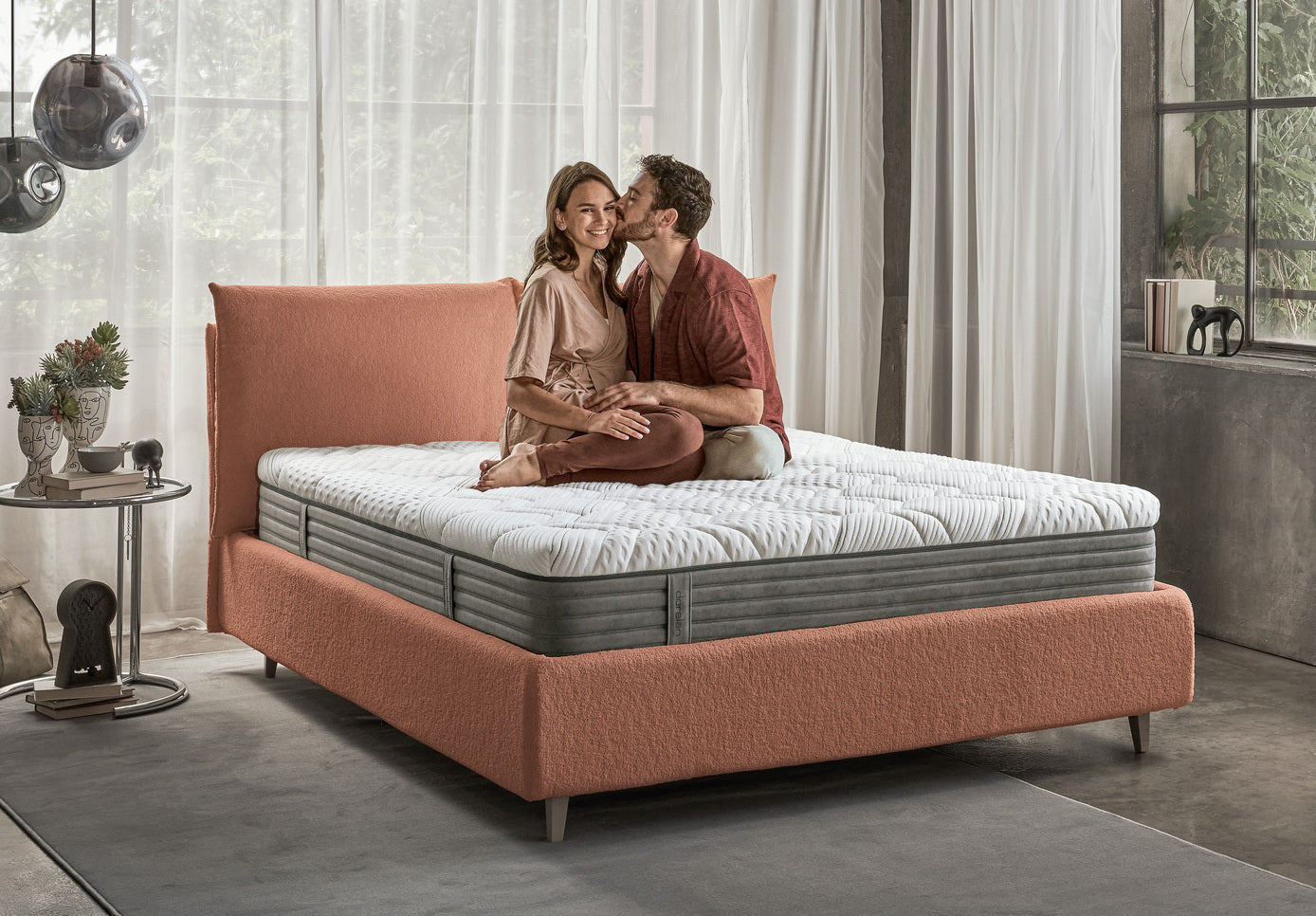 ragazzi si abbracciano su materasso rising della linea innovatie di dorelan, su un letto arancione in  boucle